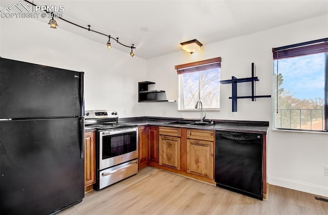 kitchen featuring black appliances, light wood-type flooring, and sink