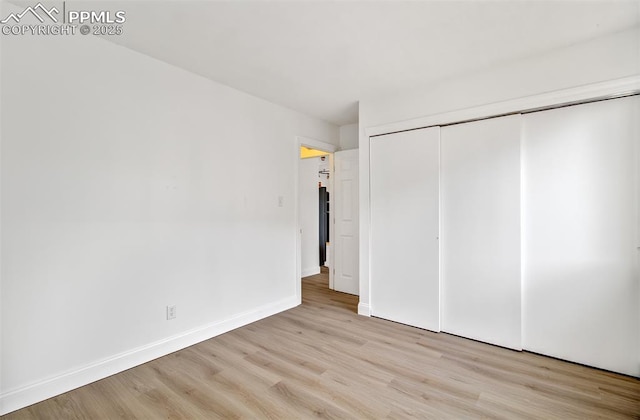 unfurnished bedroom featuring a closet and light hardwood / wood-style floors