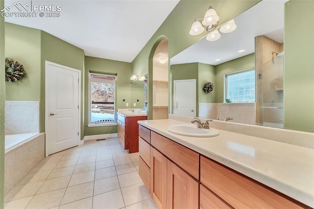 bathroom with tile patterned flooring, vanity, and plus walk in shower