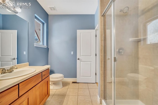 bathroom featuring tile patterned floors, a shower with door, and toilet