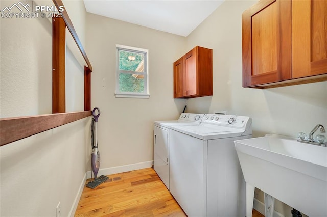 laundry room with cabinets, separate washer and dryer, light hardwood / wood-style floors, and sink