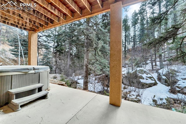 snow covered patio with a hot tub