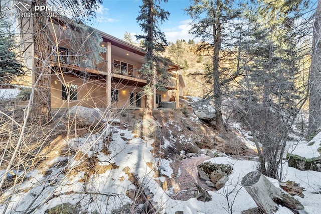 snow covered property with a balcony