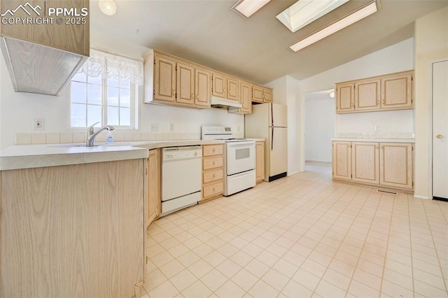 kitchen with light brown cabinetry, lofted ceiling with skylight, sink, and white appliances