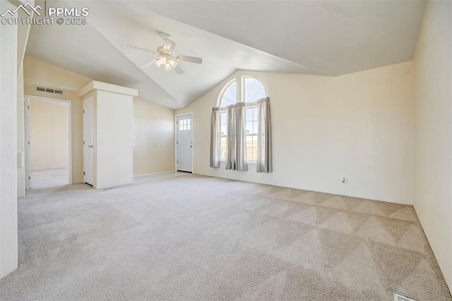 carpeted spare room with ceiling fan and lofted ceiling