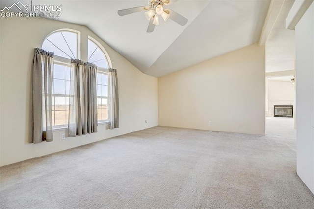 carpeted spare room featuring vaulted ceiling with beams and ceiling fan