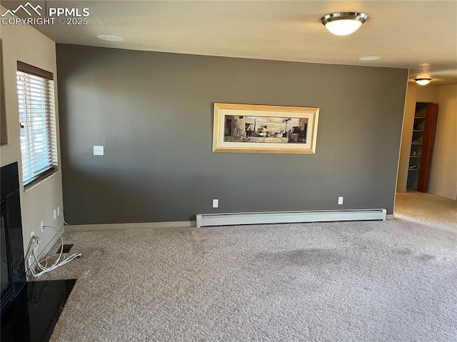 carpeted spare room featuring baseboard heating