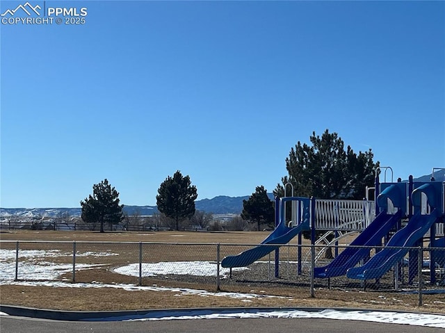 snow covered playground with a mountain view