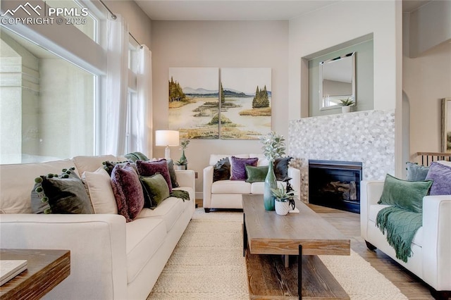 living room with light hardwood / wood-style floors and a tiled fireplace