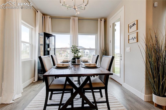 dining area featuring an inviting chandelier and light hardwood / wood-style floors