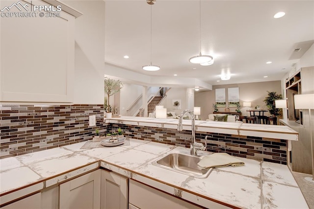 kitchen with sink, white cabinetry, decorative backsplash, and tile counters