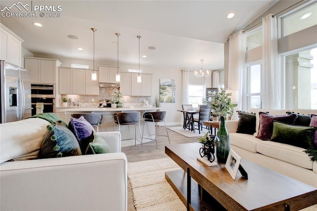 living room with a notable chandelier and light hardwood / wood-style floors