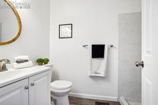 bathroom with toilet, hardwood / wood-style floors, and vanity