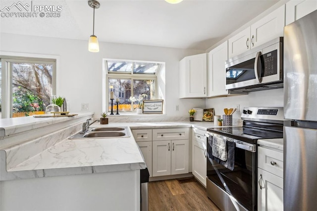 kitchen with white cabinets, appliances with stainless steel finishes, decorative light fixtures, dark hardwood / wood-style flooring, and sink