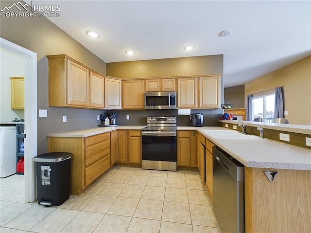 kitchen with light brown cabinetry, sink, light tile patterned floors, kitchen peninsula, and stainless steel appliances