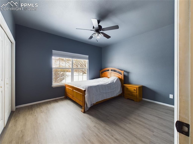 bedroom featuring ceiling fan, a closet, and light hardwood / wood-style flooring