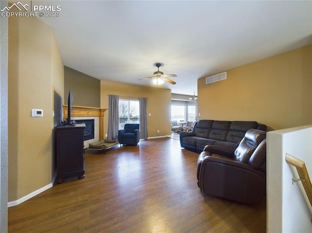 living room with dark hardwood / wood-style flooring and ceiling fan