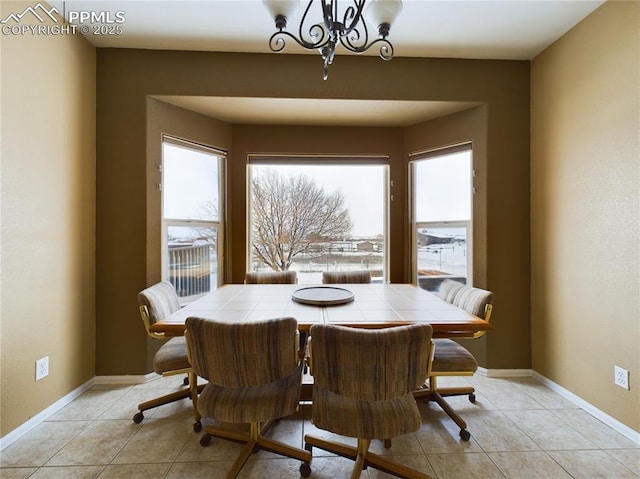 dining area with light tile patterned floors, a wealth of natural light, and a chandelier