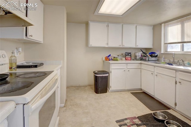 kitchen featuring sink, white cabinetry, and white range with electric stovetop