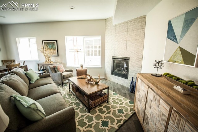 living room with hardwood / wood-style floors and a tiled fireplace