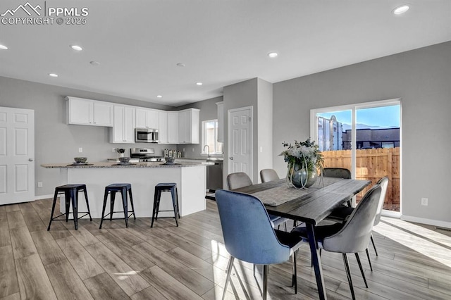 dining space with light hardwood / wood-style floors and sink