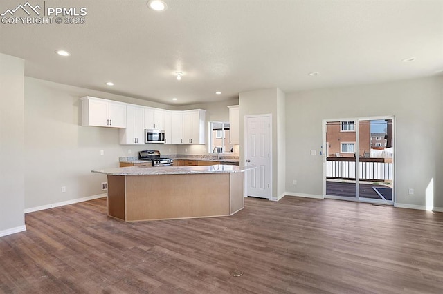 kitchen with white cabinetry, a center island, sink, dark hardwood / wood-style flooring, and appliances with stainless steel finishes