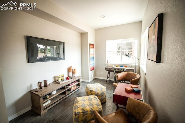 living area with a healthy amount of sunlight and dark hardwood / wood-style flooring