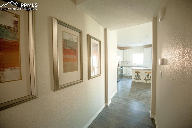 corridor featuring hardwood / wood-style floors and a textured ceiling