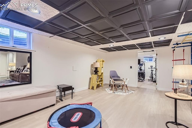 playroom with light hardwood / wood-style flooring and coffered ceiling