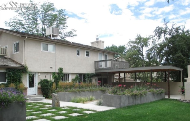 rear view of house with cooling unit and a lawn