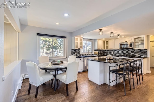 kitchen with dark hardwood / wood-style floors, a kitchen island, sink, stainless steel appliances, and white cabinets