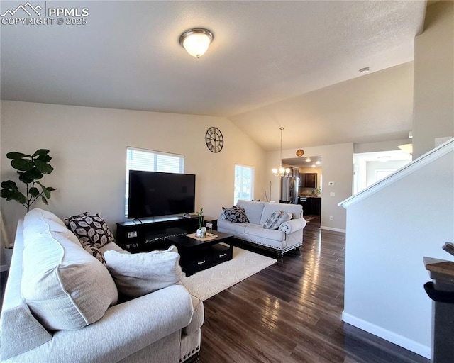 living room featuring an inviting chandelier, vaulted ceiling, and dark hardwood / wood-style floors