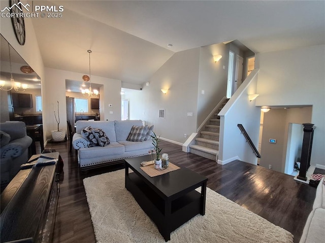 living room featuring dark wood-type flooring, lofted ceiling, and a notable chandelier