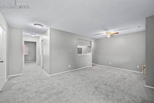 empty room with ceiling fan, carpet, and a textured ceiling