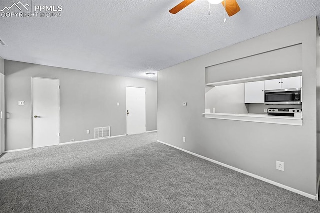 empty room with ceiling fan, carpet floors, and a textured ceiling