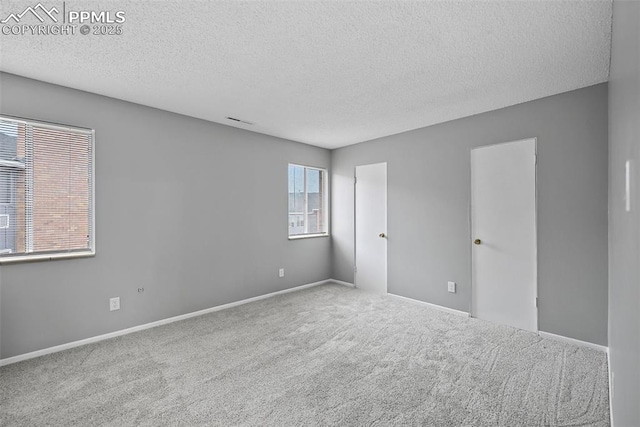 carpeted spare room with a textured ceiling