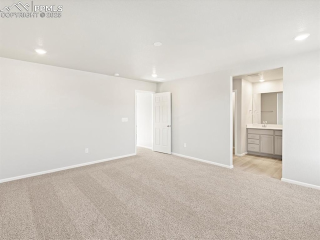 unfurnished room with sink and light carpet