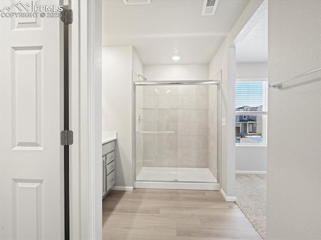 bathroom with vanity, an enclosed shower, and wood-type flooring