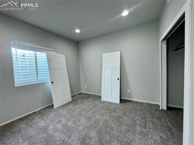 unfurnished bedroom featuring a closet and dark colored carpet