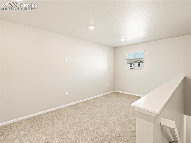 empty room featuring carpet, baseboards, and recessed lighting