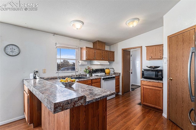 kitchen with sink, a textured ceiling, white gas range oven, kitchen peninsula, and dark hardwood / wood-style flooring