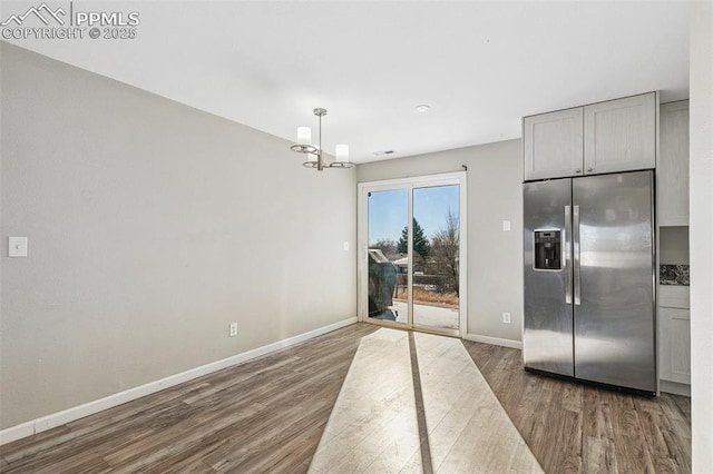 kitchen featuring dark hardwood / wood-style flooring, gray cabinetry, a chandelier, stainless steel fridge with ice dispenser, and hanging light fixtures