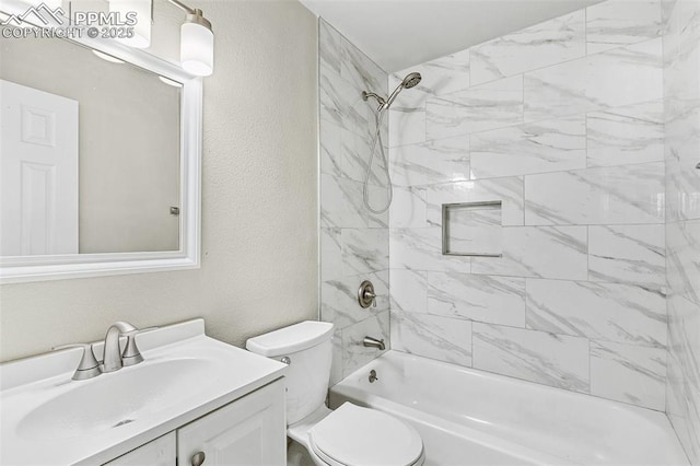 full bathroom featuring vanity, tiled shower / bath combo, and toilet