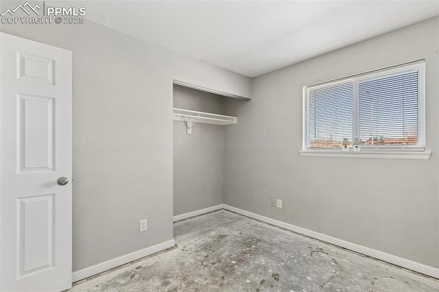 unfurnished bedroom with a closet and concrete floors