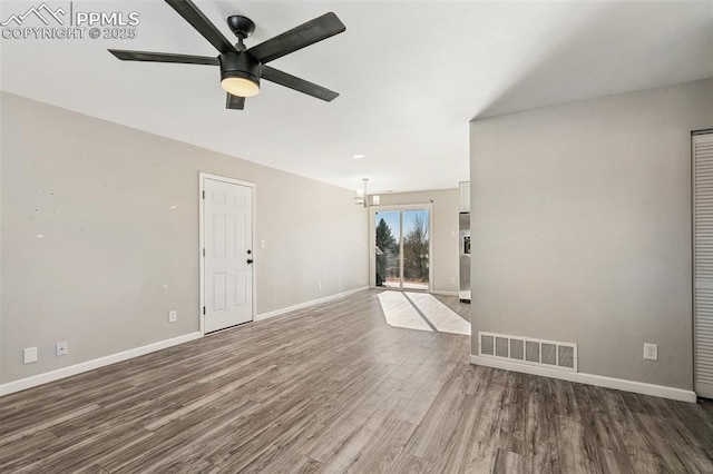 unfurnished living room featuring dark hardwood / wood-style floors and ceiling fan