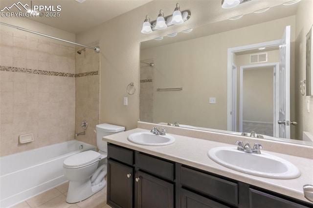 full bathroom with toilet, tile patterned flooring, tiled shower / bath, and vanity