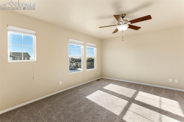 carpeted spare room featuring ceiling fan