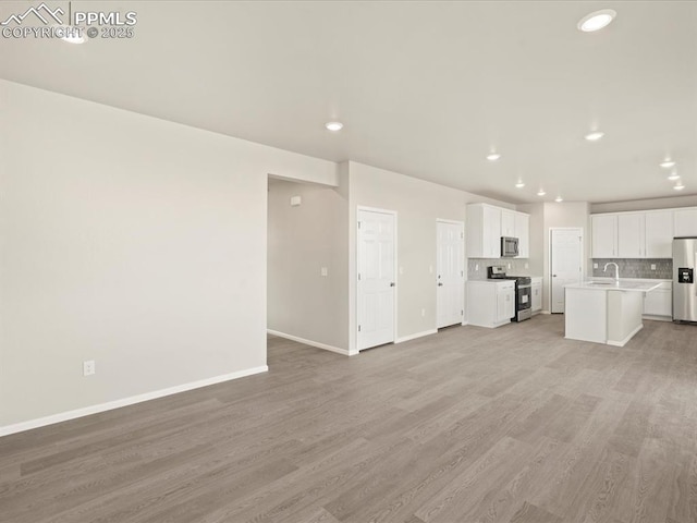 unfurnished living room featuring light hardwood / wood-style flooring and sink