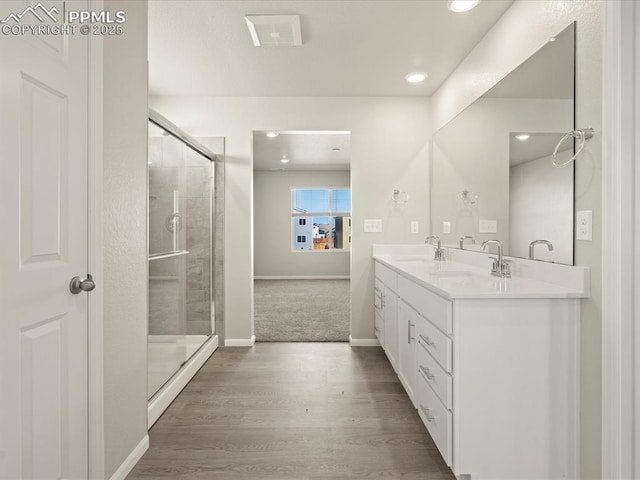 bathroom with walk in shower, hardwood / wood-style floors, and vanity