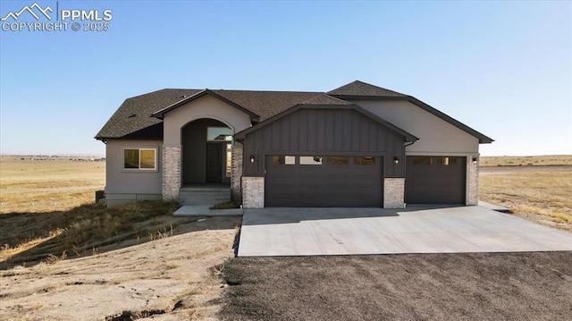 view of front of house with a garage and a rural view